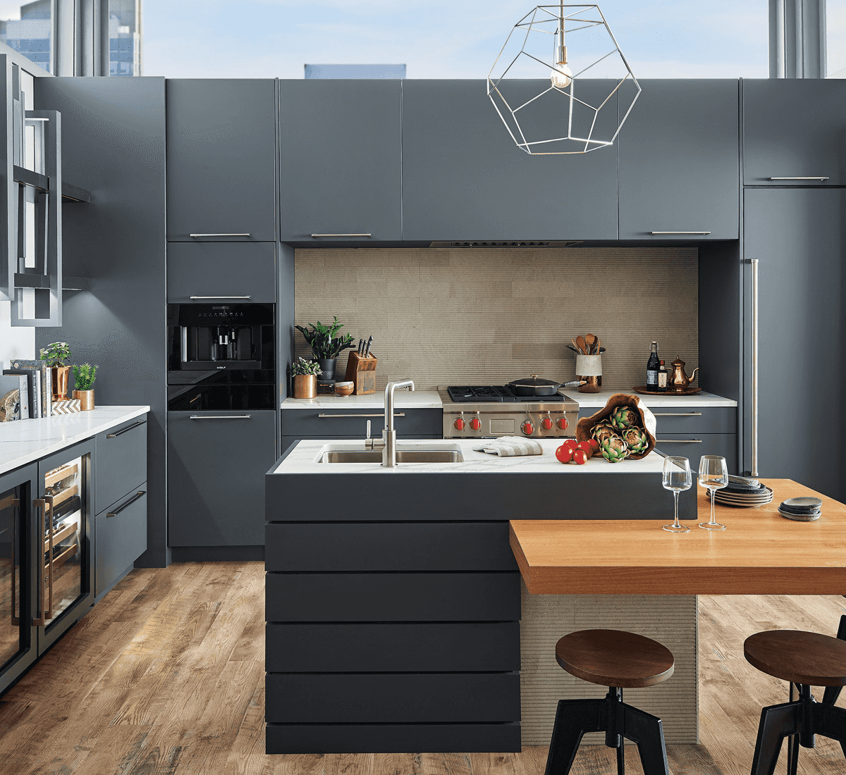 modern kitchen with dark blue cabinets, light wood floors, and overhead window lighting